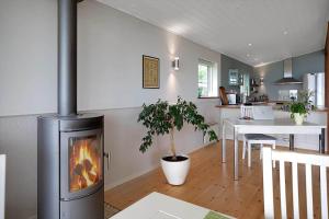 a kitchen and dining room with a fireplace in a living room at 14242-Vig-Maglehojvej-6 in Vig