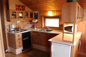 a kitchen with a stove and a sink in a cabin at 16626-Farevejle-Rormosen-56 in Fårevejle