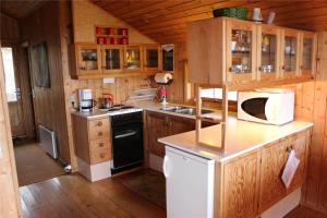 a kitchen with wooden cabinets and a white microwave at 16626-Farevejle-Rormosen-56 in Fårevejle