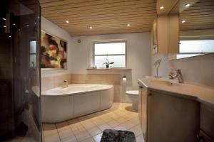a bathroom with a tub and a toilet and a sink at 16624-Farevejle-Stihojvej-25 in Fårevejle +17 photos
