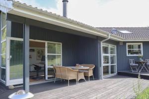 a patio with a table and chairs on a deck at 16624-Farevejle-Stihojvej-25 in Fårevejle