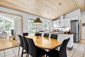 a kitchen and dining room with a wooden table and chairs at 13387-Vig-Vej-11-4 in Vig