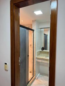 a bathroom with a glass door leading to a tub at Caesar Towers Hotel by Asas Tur in Recife +106 photos