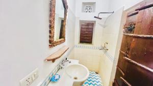 a bathroom with a toilet and a sink and a mirror at Mosaics Guest House in Jaipur