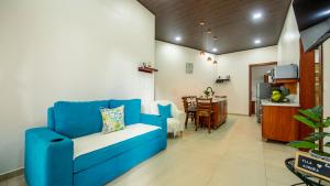 a living room with a blue couch and a dining room at Villa Aurora with Jacuzzi in La Fortuna in Fortuna