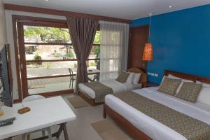 a hotel room with two beds and a window at Karancho Beach House in Mactan