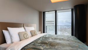 a bedroom with a large bed with a large window at HOTELA Niseko Towers in Kutchan +149 photos