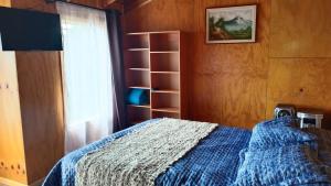 a bedroom with a bed and a book shelf at Cabañas Canaan in Coñao