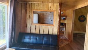 a leather couch in a room with a mirror at Cabañas Canaan in Coñao