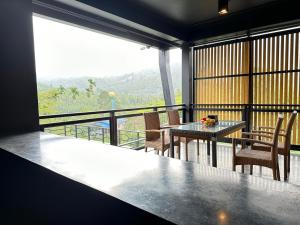 a room with a table and chairs and a balcony at D’Endless Resotel in Baen