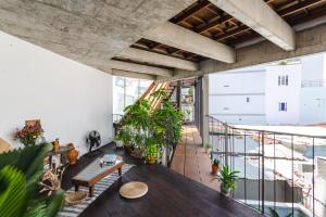 an apartment with a balcony with plants and a table at The Still Slow & Sip in Nha Trang
