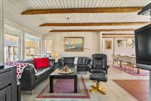 a living room with a couch and a table and a tv at LF14223-Roslev-Livovej-9 in Roslev