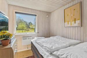 a small bedroom with a bed and a window at LF14223-Roslev-Livovej-9 in Roslev