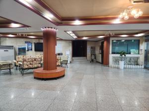 a lobby with chairs and a column in a building at Seoraksan Youth Hostel in Sokcho