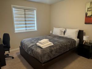 a bedroom with a bed with two towels on it at Peace Home in Calgary