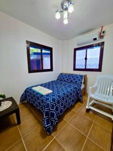 a bedroom with a bed and a chair in it at Nice Whitepebbles Beach Front in Sibulan