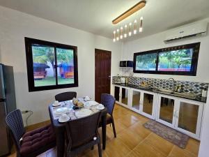 a dining room with a table and a kitchen at Nice Whitepebbles Beach Front in Sibulan