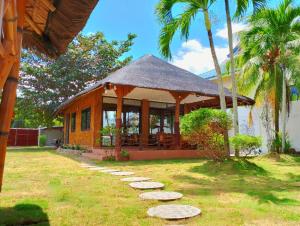a small house with a gazebo in a yard at Nice Whitepebbles Beach Front in Sibulan