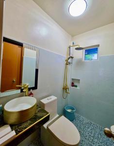 a bathroom with a toilet and a sink and a mirror at Nice Whitepebbles Beach Front in Sibulan +24 photos