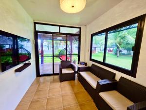 a living room with two couches and two windows at Nice Whitepebbles Beach Front in Sibulan