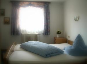 a bedroom with a bed with a window at Hotel Wegis Garni in Bermatingen