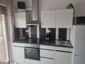 a kitchen with white cabinets and a sink at Villa Müller in Poreč +4 photos
