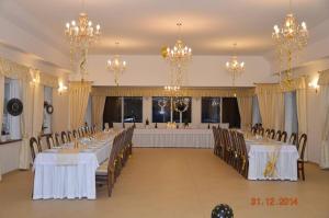 a banquet hall with tables and chairs and chandeliers at Zielona Dolina in Nowogródek Pomorski