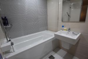 a bathroom with a tub and a sink and a bath tub at Nova hotel in Samgong