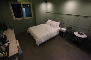 a bedroom with a bed with white sheets and pillows at Nova hotel in Samgong