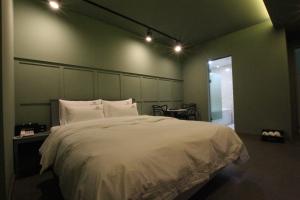 a bedroom with a large white bed and a table at Nova hotel in Samgong
