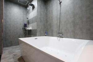 a bathroom with a white tub and a shower at Nova hotel in Samgong
