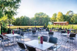 an outdoor patio with tables and chairs at Leonardo Hotel Köln Bonn Airport in Cologne