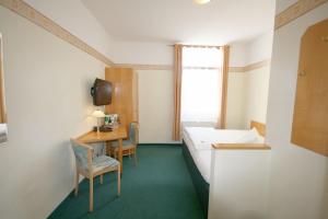 Zimmer mit einem Bett, einem Schreibtisch und einem Fenster in der Unterkunft Classic Inn in Heidelberg