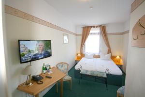 a hotel room with a bed and a tv at Classic Inn in Heidelberg