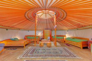 a living room with orange furniture and a large tent at Le Village des Templiers in Trie-Château