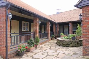 a brick house with a porch with potted plants at The Green Man Stanford in Southill