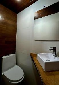 a bathroom with a white toilet and a sink at Gruta do Pavão in Paraty