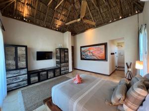 a living room with a bed and a tv at Flamingo Blue - Casa Boutique - Adults Only in El Cuyo