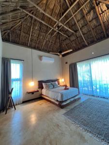a bedroom with a bed and some windows at Flamingo Blue - Casa Boutique - Adults Only in El Cuyo +85 photos