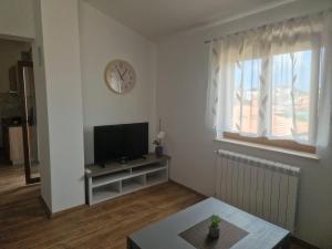 a living room with a tv and a clock on the wall at Villa Müller in Poreč
