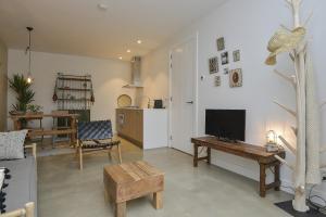 sala de estar con TV y mesa en Follow The Sun Apartment, en Zandvoort