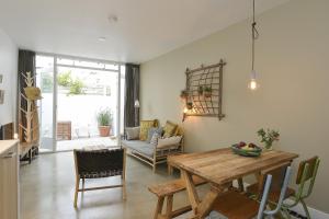 cocina y sala de estar con mesa de madera en Follow The Sun Apartment, en Zandvoort