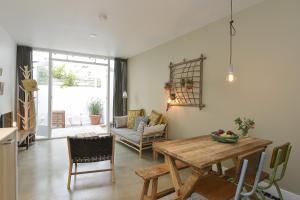 a kitchen and living room with a wooden table at Follow The Sun Apartment in Zandvoort