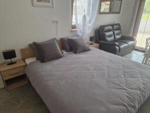 a bedroom with a large bed and a leather chair at Villa Müller in Poreč +17 photos