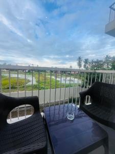 a balcony with two black chairs and a table at Celestial Negombo Resort Apartment ML in Negombo
