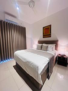 a bedroom with a large bed and a window at Celestial Negombo Resort Apartment ML in Negombo