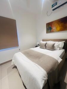 a bedroom with a large bed with white sheets and pillows at Celestial Negombo Resort Apartment ML in Negombo