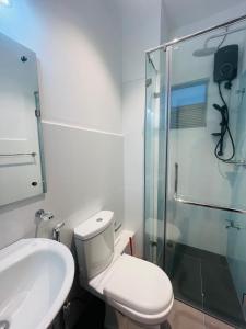 a bathroom with a toilet and a glass shower at Celestial Negombo Resort Apartment ML in Negombo