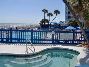 a swimming pool at a resort with the beach in the background at Islander Beach Resort - New Smyrna Beach in New Smyrna Beach