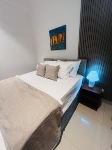 a bedroom with a bed with a lamp on a table at Celestial Negombo Resort Apartment ML in Negombo